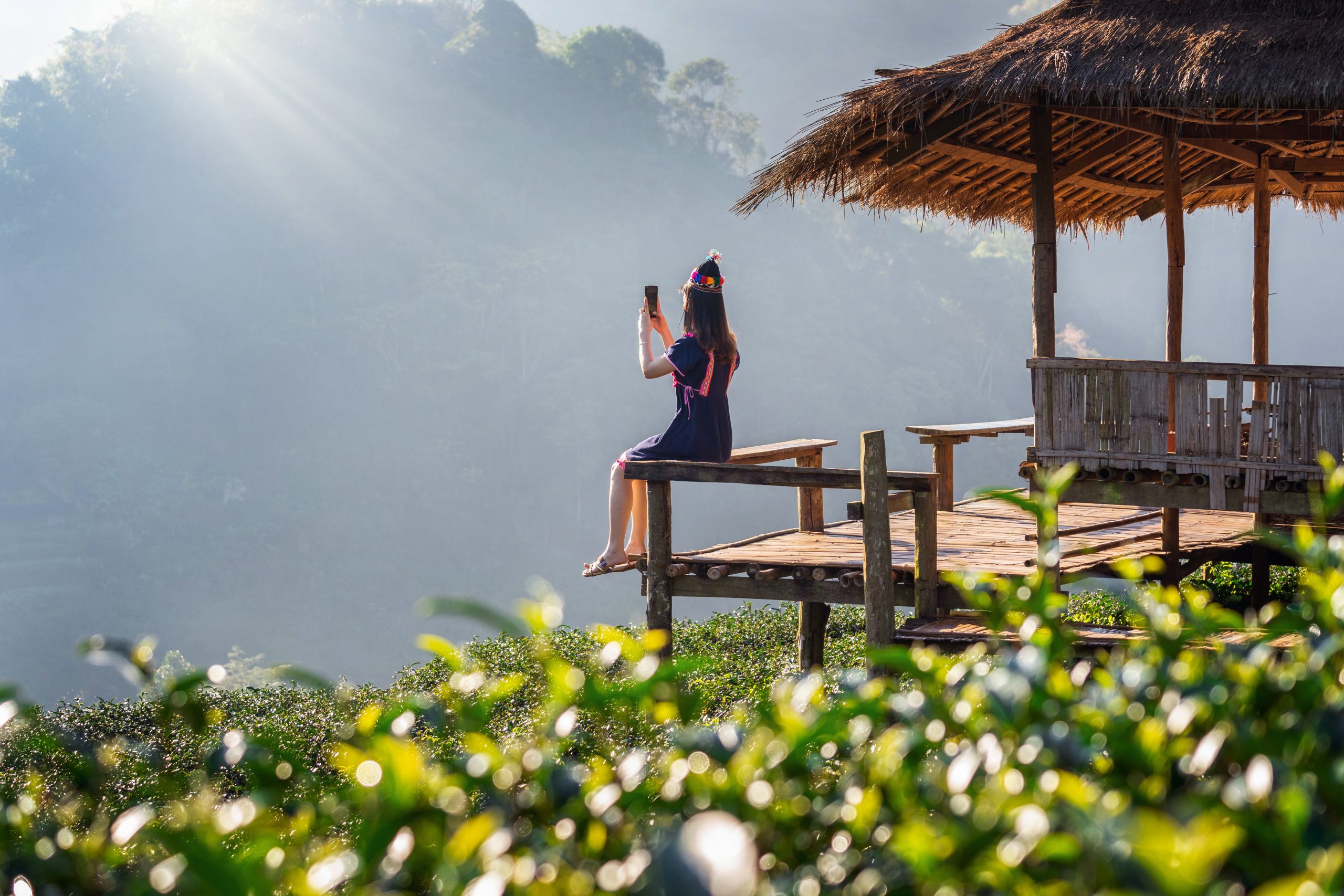 Woman wearing hill tribe dress sitting on the hut in green tea f